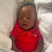 Dior is registered to the contest to win money with this photo: baby, sleeping, infant, red_clothing, blanket, cozy, peaceful, newborn, child, soft_texture, portrait, wrapped, rest, cute, hands, face, head, indoor, comfort, nap