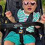 Quinn joined the competition — help win amazing prizes! baby, child, stroller, sunglasses, pink, heart_shaped, hair_clip, graco, outdoor, smiling, happy, toddler, clothing, green_shorts, striped_shirt, seatbelt, foot, hand, sunlight, person
