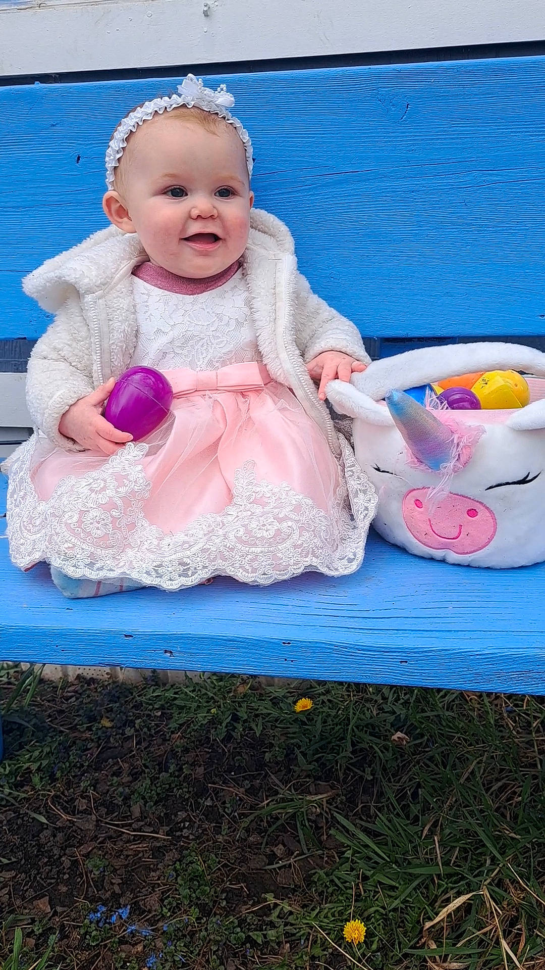 Nova Ann is registered to the contest to win money with this photo: baby, baby_products, baby_toddler_clothing, child, dress, face, fashion_accessory, fun, grass, hair_accessory, happy, magenta, pattern, person, pink, play, recreation, sitting, sleeve, smile