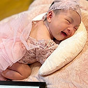 Keizha Xen joined the competition — help win amazing prizes! baby, infant, smiling, pink_lace, headband, pillow, blanket, sleeping_position, cute, happy, newborn, soft_texture, indoors, portrait, person, small_child, cozy, resting, toddler, delicate