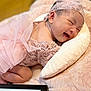 baby, infant, smiling, pink_lace, headband, pillow, blanket, sleeping_position, cute, happy, newborn, soft_texture, indoors, portrait, person, small_child, cozy, resting, toddler, delicate