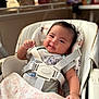 baby, infant, smile, harness, baby_seat, blanket, clothing, indoor, cute, chubby_cheeks, face, person, comfort, soft, home, seat, child, young, portrait, relaxing