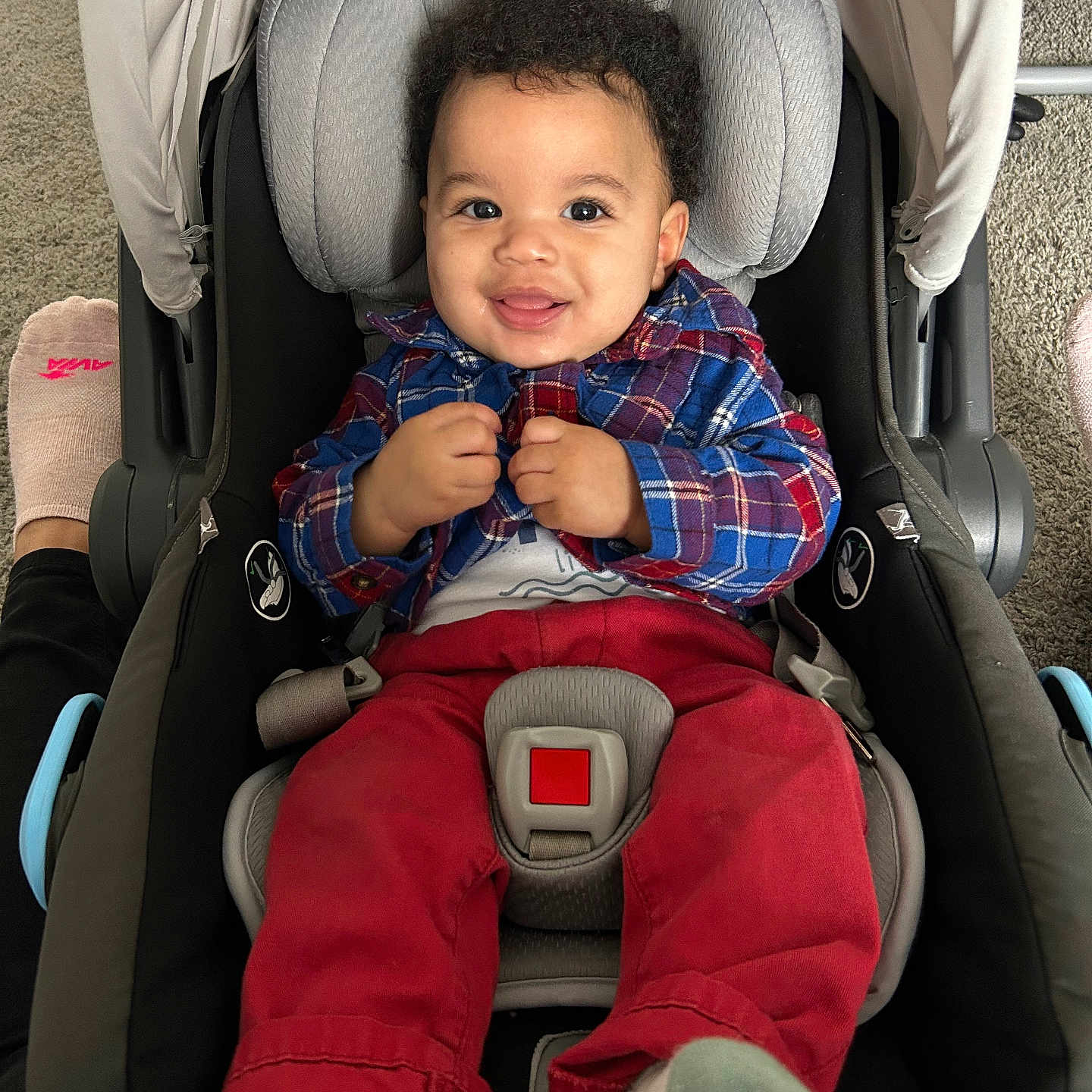 Micielo joined the competition — help win amazing prizes! baby, child, smiling, car_seat, plaid_shirt, red_pants, socks, infant, indoor, person, footwear, car_seat_harness, happy, cute, portrait, child_seat, car_seat_padding, car_seat_strap, car_seat_buckle, car_seat_cover