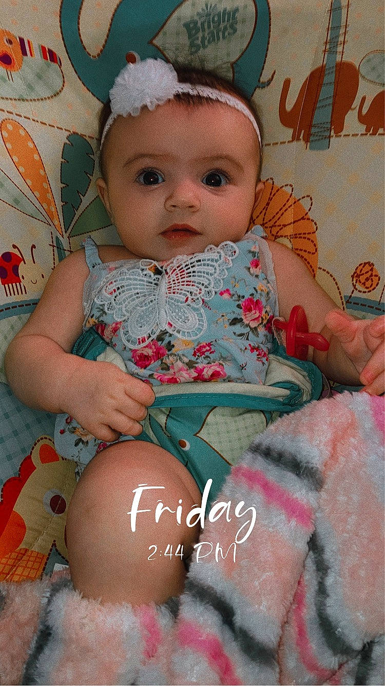 Scarlett is registered to the contest to win money with this photo: baby, baby_toddler_clothing, cheek, child, comfort, eye, face, facial_expression, finger, happy, head, iris, organ, pattern, person, pink, sitting, skin, textile, thigh