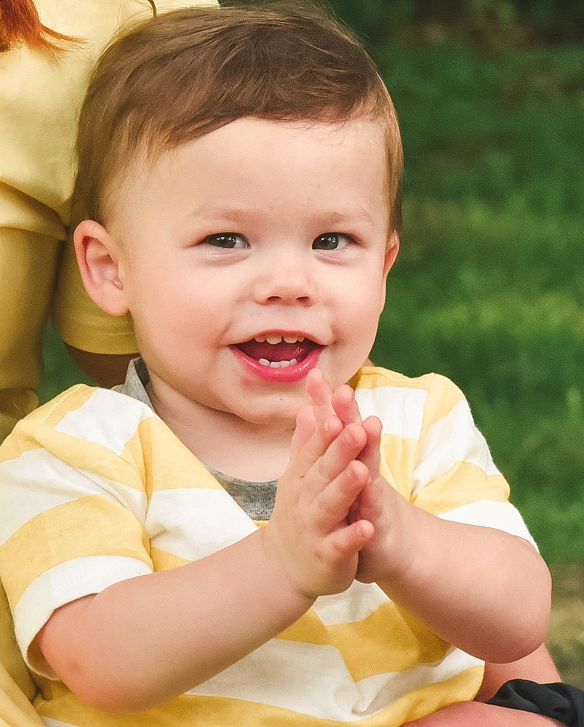 Ledger is registered to the contest to win money with this photo: baby, baby_toddler_clothing, cheek, child, eyelash, face, finger, fun, gesture, grass, hand, happy, lip, nose, people_in_nature, person, sitting, skin, smile, thumb