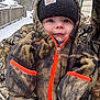 Dean is registered to the contest to win money with this photo: baby, child, face, winter, snow, outdoor, clothing, jacket, beanie, hood, camouflage, cold, cute, portrait, person, frost, season, nature, expression, young