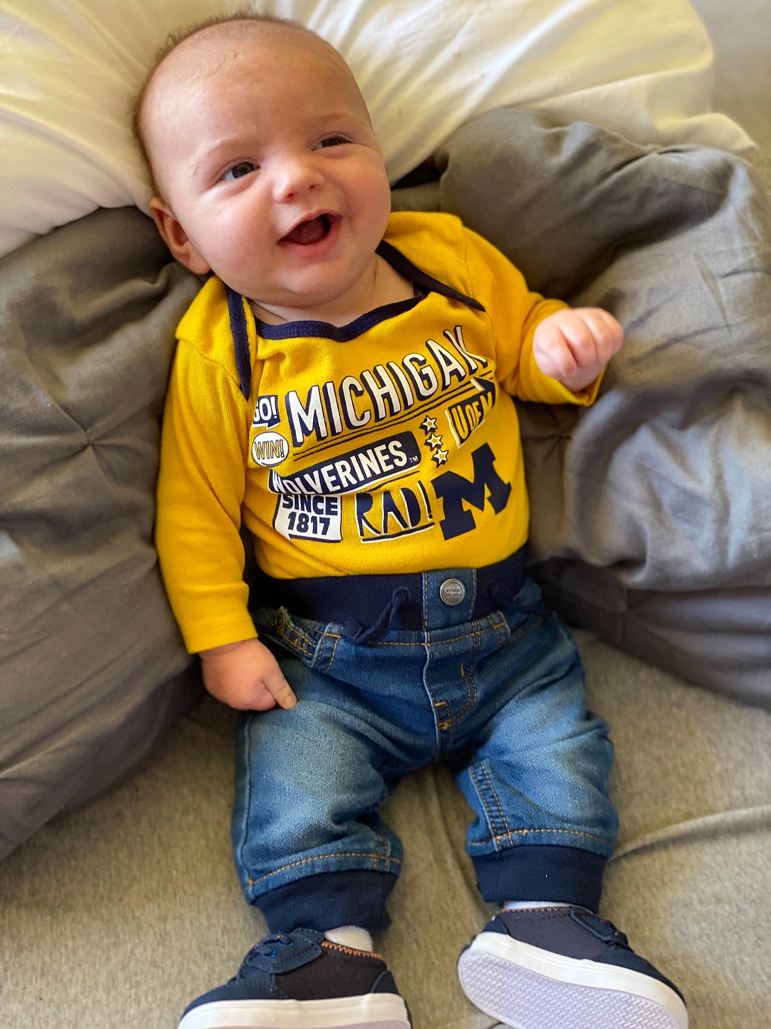 Bryer is registered to the contest to win money with this photo: baby, cheek, child, cool, facial_expression, footwear, hoodie, jacket, jeans, leg, outerwear, person, play, shoe, sitting, sleeve, smile, t_shirt, toddler, yellow