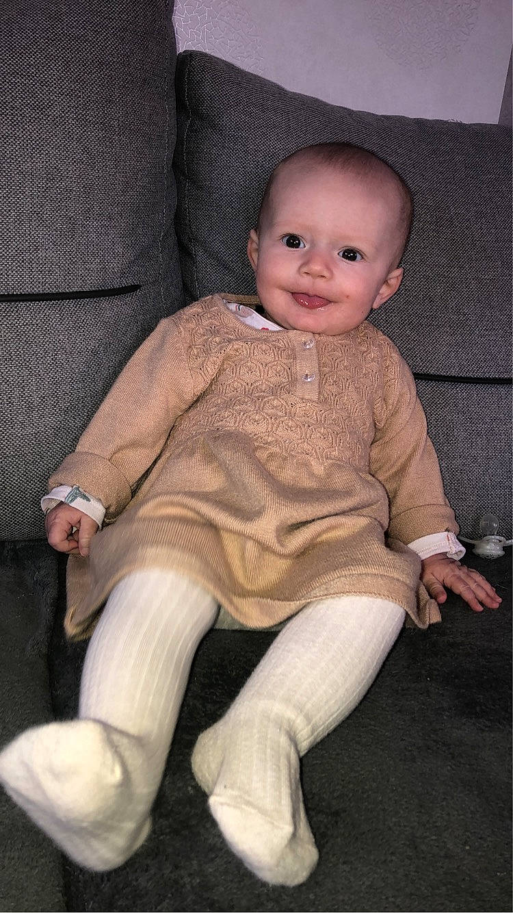 Ana participe au concours pour gagner de l'argent avec cette photo : baby, baby_toddler_clothing, cheek, child, comfort, face, foot, head, human_body, human_leg, iris, joy, knee, lap, person, sitting, sleeve, smile, t_shirt, thigh