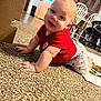 baby, crawling, red_shirt, carpet, indoor, child, infant, home, kitchen, dining_chairs, cabinet, floor, smiling, cute, person, shorts, playtime, young_child, furniture, casual