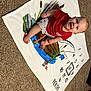 Riley is registered to the contest to win money with this photo: baby, infant, child, smiling, sitting, milestone_blanket, carpet, red_shirt, cute, indoors, portrait, happy, young_child, feet, hands, face, clothing, decorative_blanket, months, numbers