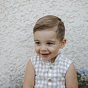 Felix participe au concours pour gagner de l'argent avec cette photo : toddler, child, smile, face, portrait, sleeveless, checkered, beige, white, hair, cute, happy, seated, wall, texture, outdoor, buttoned, skin, person, clothing