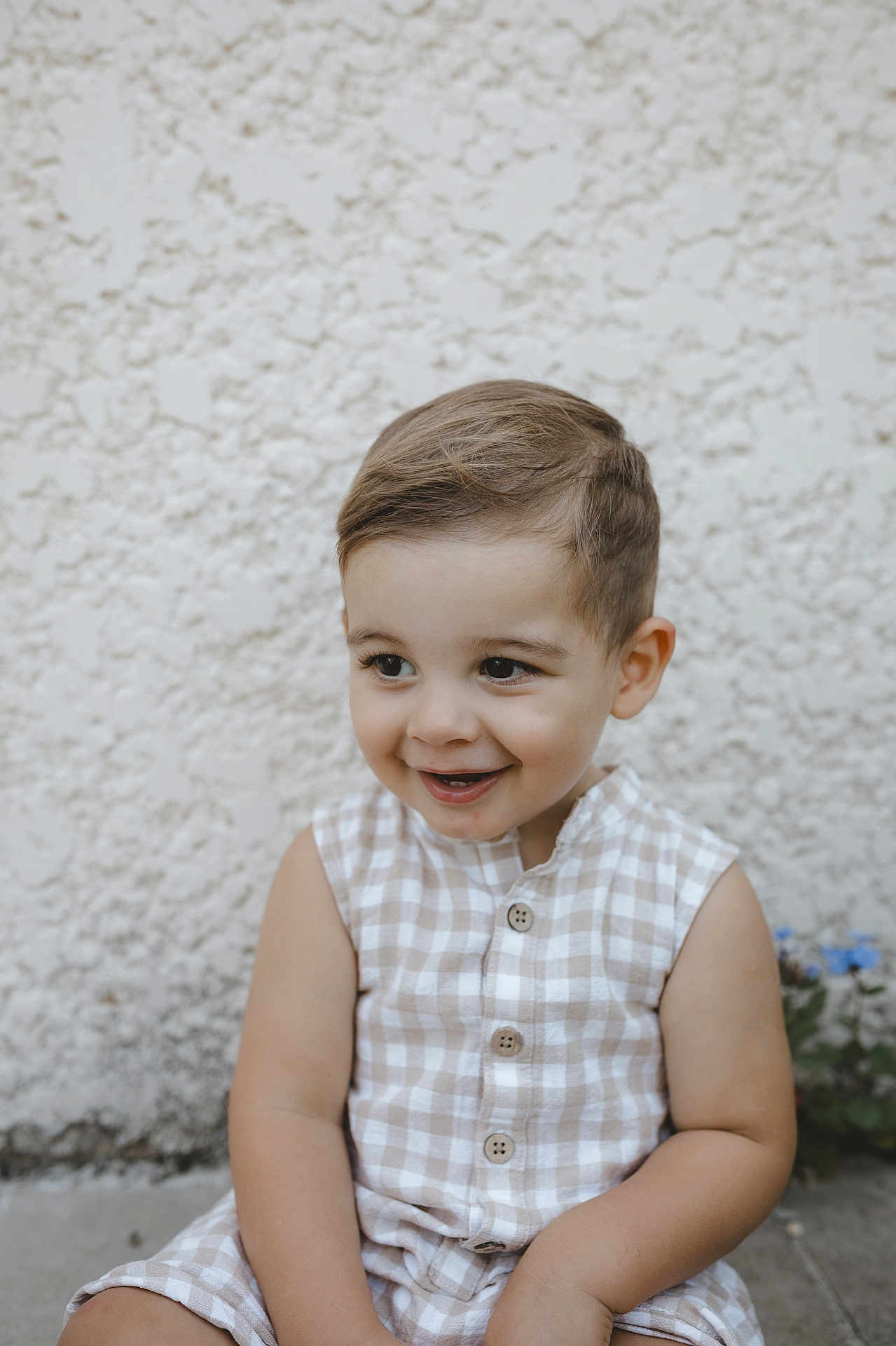 Felix participe au concours pour gagner de l'argent avec cette photo : toddler, child, smile, face, portrait, sleeveless, checkered, beige, white, hair, cute, happy, seated, wall, texture, outdoor, buttoned, skin, person, clothing
