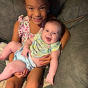 Breanna is registered to the contest to win money with this photo: child, baby, smiling, happy, couch, indoor, family, holding, sitting, clothing, cute, infant, person, portrait, joy, toddler, young, candid, together, love