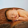 Breanna is registered to the contest to win money with this photo: newborn, baby, sleeping, face, skin, arm, hand, leather, carving, texture, brown, relaxation, peaceful, portrait, closeup, infant, cute, resting, soft, young