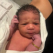 Aziyah joined the competition — help win amazing prizes! newborn, baby, infant, towel, bracelet, curly_hair, skin, hand, face, person, wrapped, bedroom, blanket, sleepwear, cute, indoors, soft, skin_tone, portrait, resting