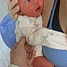 Nova is registered to the contest to win money with this photo: newborn, baby, infant, child, face, portrait, being_held, adult_hands, family, caregiving, onesie, sleepwear, blue_blanket, indoor, close_up, baby_foot, newborn_skin, looking_at_camera, text_overlay, photograph