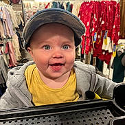 Ryatt joined the competition — help win amazing prizes! baby, child, shopping_cart, cap, smile, clothing_store, jacket, yellow_shirt, rack, shopping, happy, face, retail, apparel, infant, store_interior, cute, person, headwear, casual_wear