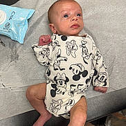 Ryan Jr joined the competition — help win amazing prizes! baby, newborn, infant, onesie, disney, mickey_mouse, donald_duck, goofy, medical_table, wipes, paper_sheet, clothing, person, skin, foot, hand, head, face, indoor, curious