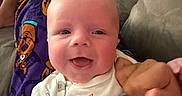 Jackson joined the competition — help win amazing prizes! baby, child, pajamas, sitting, couch, smiling, indoors, face, person, clothing, hand, blanket, happy, cute, home, relaxing, portrait, young_child, sibling, furniture