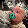 Jackson is registered to the contest to win money with this photo: baby, pacifier, infant, closeup, face, head, person, child, indoors, fabric, blanket, baby_rocker, floor, wood_floor, curious, resting, clothing, soft, cozy, home
