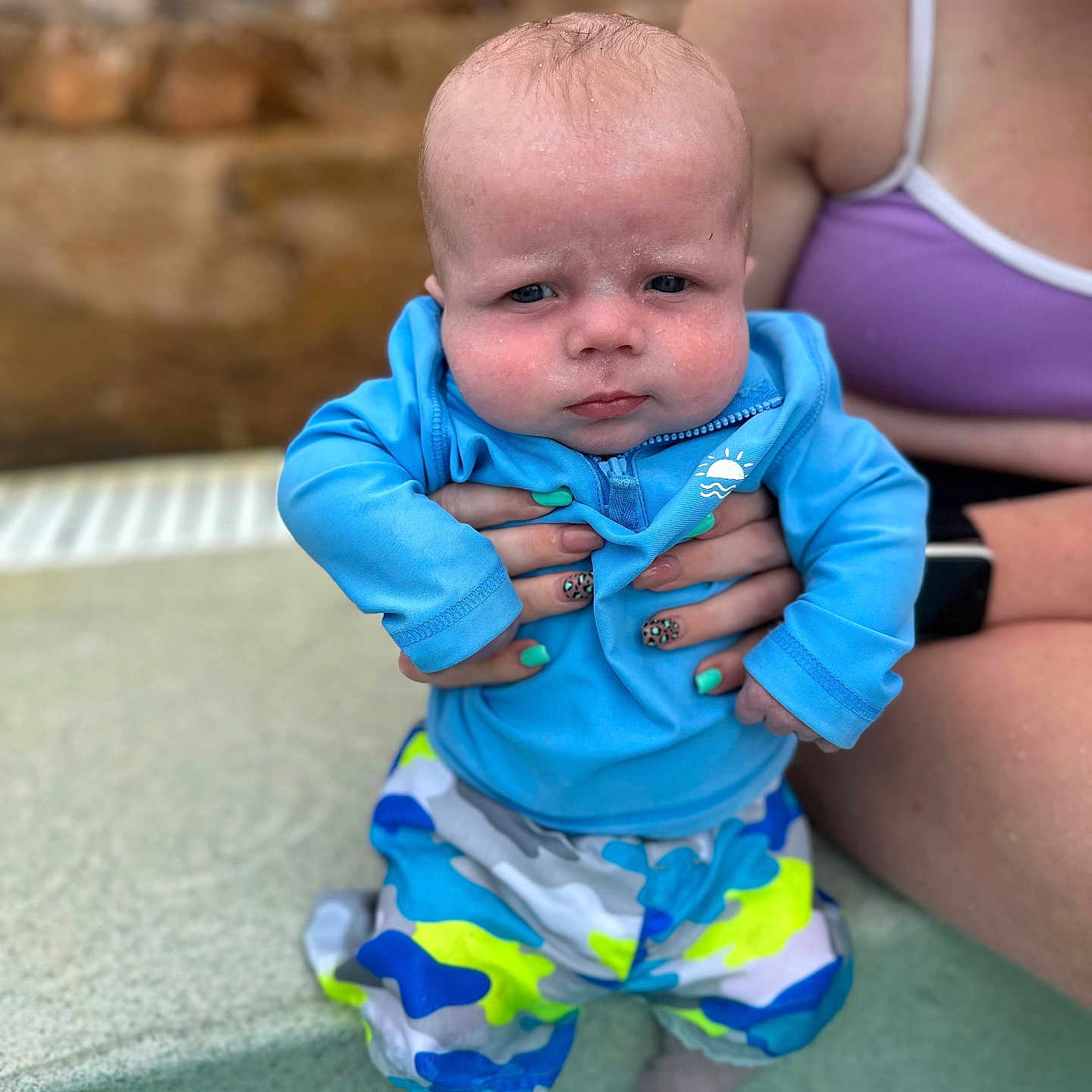 Jackson is registered to the contest to win money with this photo: baby, child, pool, water, blue_jacket, colorful_shorts, person, hand, nail_art, leopard_print, skin, adult, summer, outdoor, water_splash, expression, face, legs, swimwear, holding