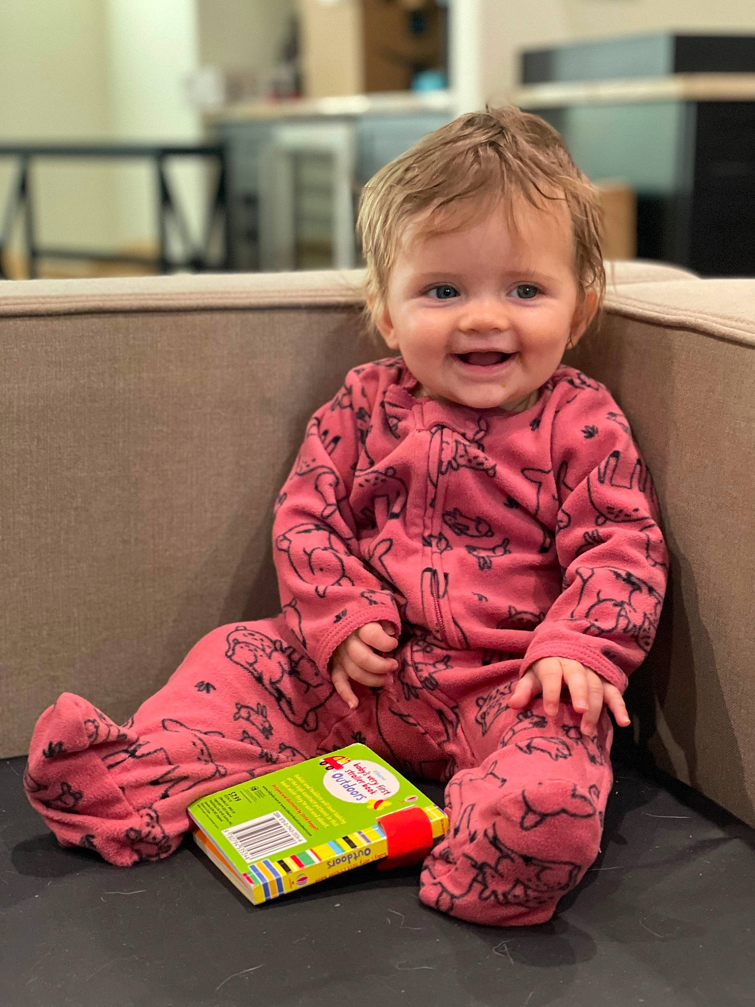 Bristol is registered to the contest to win money with this photo: baby, baby_toddler_clothing, carmine, cheek, child, couch, face, flooring, fun, happy, head, human_body, joy, magenta, person, room, sitting, skin, sleeve, smile