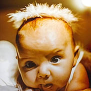 Ange a rejoint le concours — aidez-le/la à gagner de superbes lots ! baby, infant, face, eyes, expression, tongue, feathers, headband, closeup, skin, cute, child, portrait, soft_light, newborn, curious, hands, lying_down, warm_tone, indoor