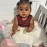 baby, child, infant, girl, curly_hair, plaid, dress, tulle_skirt, crib, blanket, wipes, soft_toys, indoor, cute, smiling, person, portrait, sitting, hand, baby_clothing