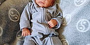Tyano a rejoint le concours — aidez-le/la à gagner de superbes lots ! baby, blanket, child, comfortable, cozy, curious_expression, cute, dinosaur_shoes, footwear, grey_clothing, indoor, infant, lying_down, onesie, patterned_blanket, portrait, small_hands, soft_texture, wide_eyes, young_child
