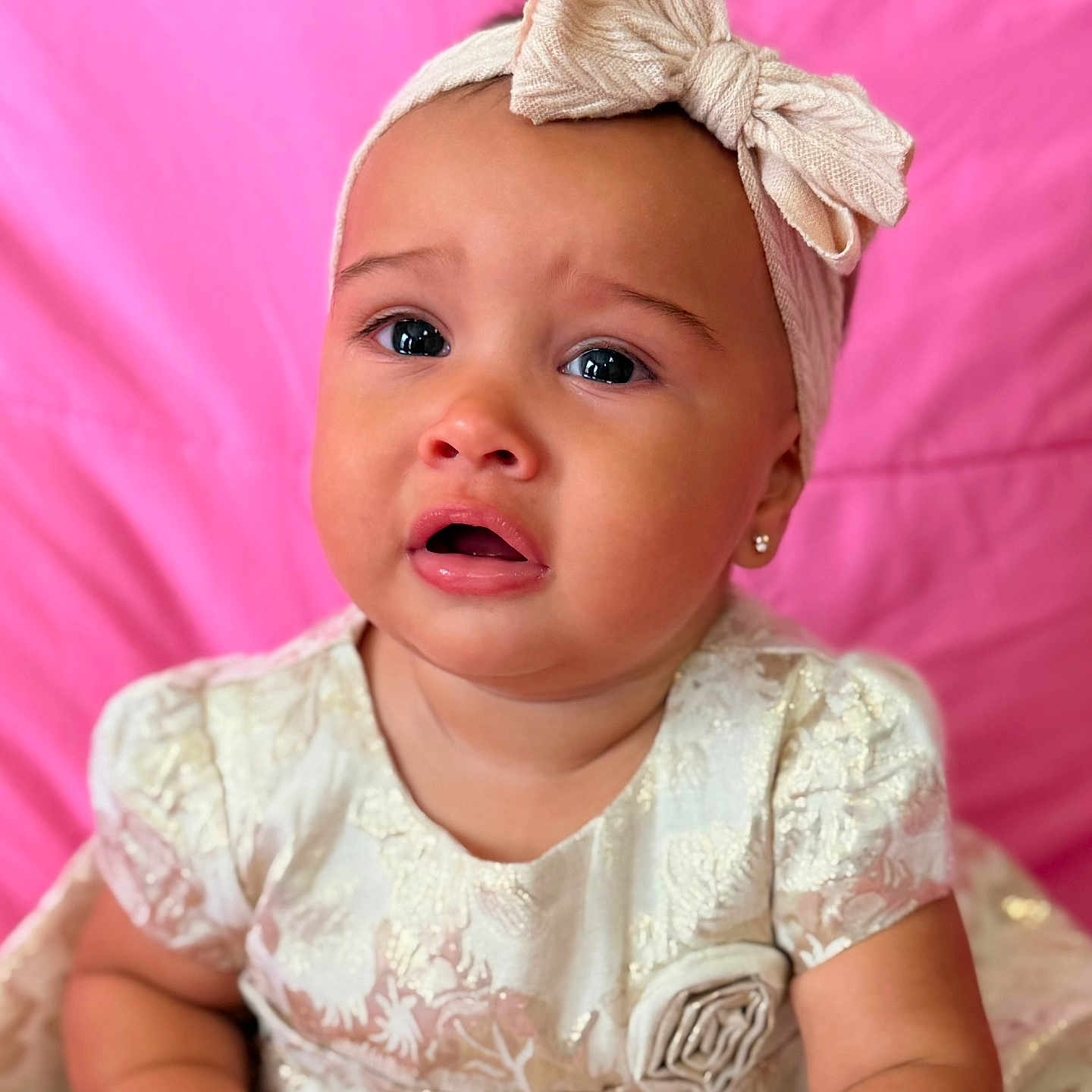Lailah is registered to the contest to win money with this photo: baby, child, toddler, girl, headband, bow, dress, lace, pink_background, cute, portrait, expression, indoor, sitting, closeup, skin, earrings, emotion, fashion, infant