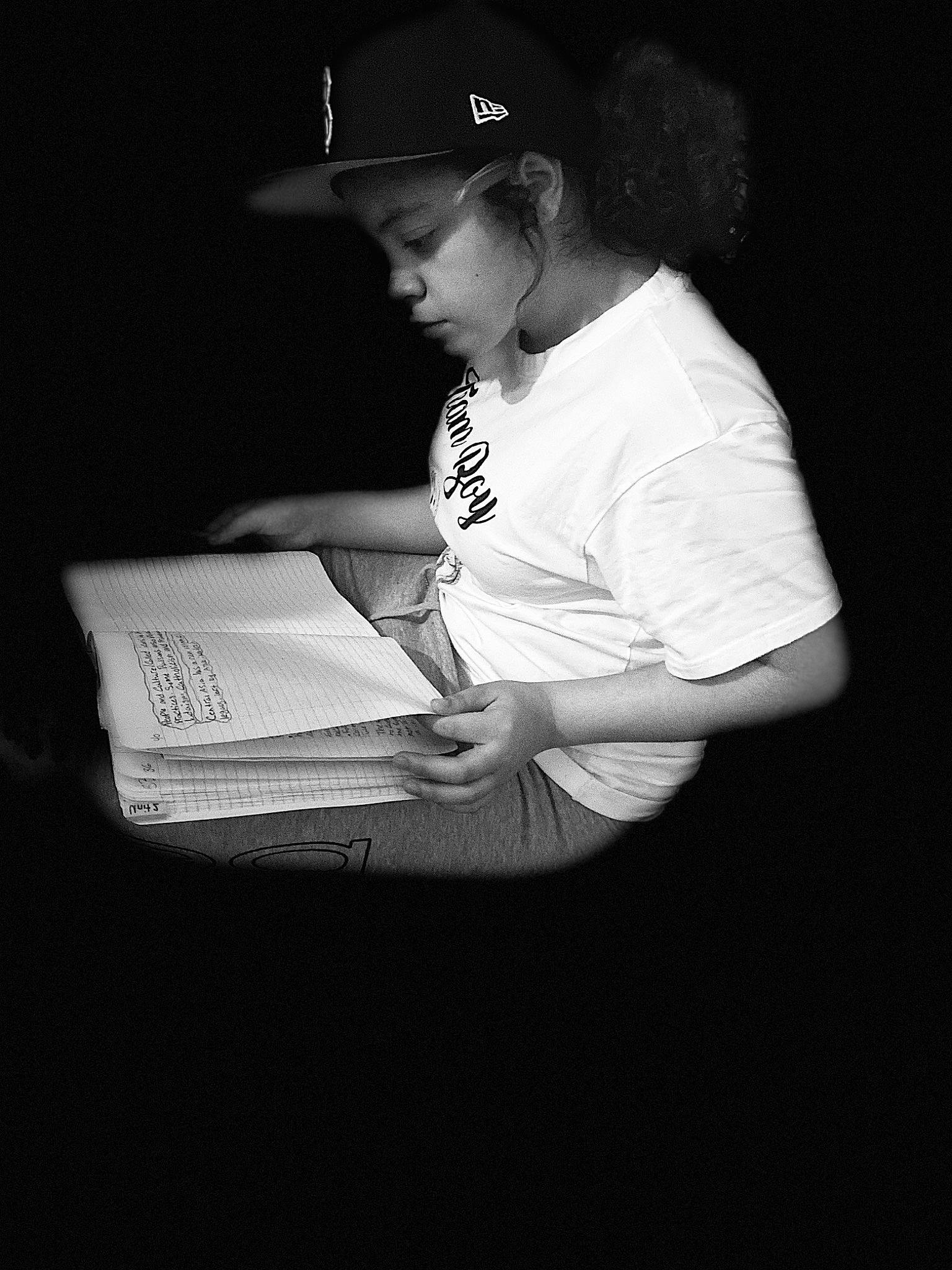 Mayalee is registered to the contest to win money with this photo: baseball_cap, book, cap, darkness, elbow, entertainment, flash_photography, font, hat, human_leg, monochrome, monochrome_photography, office_equipment, person, room, sitting, sleeve, style, t_shirt, tints_and_shades