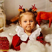 Maria participe au concours pour gagner de l'argent avec cette photo : toddler, child, holiday, christmas, festive, reindeer_antlers, red_clothing, white_collar, gift_box, fluffy_decorations, pine_cone, portrait, indoor, cute, smiling, blue_eyes, holiday_decor, soft_lighting, blurry_background, festive_headband