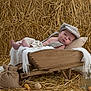 Raphaël a rejoint le concours — aidez-le/la à gagner de superbes lots ! baby, wheelbarrow, hat, blanket, pillow, hay, barn, wood, glass_jars, corn, rustic, infant, cozy, knitwear, suspenders, soft, relaxed, portrait, indoors, decor