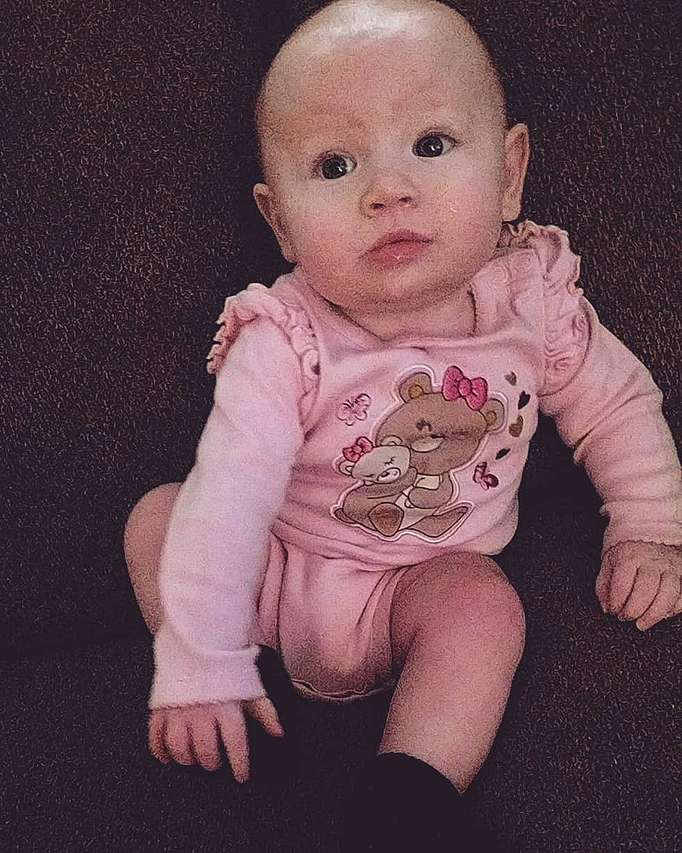 Bryleigh joined the competition — help win amazing prizes! baby, baby_making_funny_faces, baby_toddler_clothing, cheek, child, chin, eye, face, finger, hand, head, iris, lip, nose, person, pink, sitting, skin, sleeve, smile