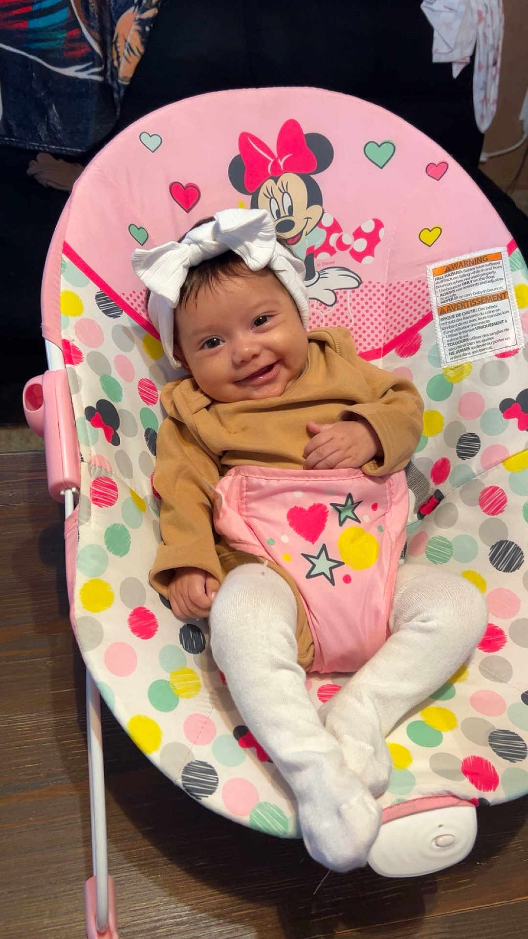 Zaiyah is registered to the contest to win money with this photo: baby, infant, headband, smile, baby_rocker, minnie_mouse, polka_dots, colorful, tights, brown_clothing, wooden_floor, toy, child, happy, cute, indoor, seat, fabric, pattern, person