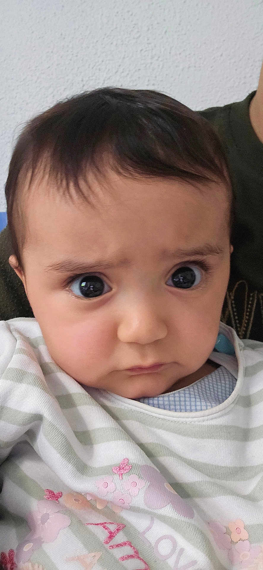 Lea a rejoint le concours — aidez-le/la à gagner de superbes lots ! baby, child, face, close_up, expression, large_eyes, striped_clothing, pastel_colors, butterfly, flower, infant, portrait, cute, adorable, human, young, indoors, textured_wall, soft_lighting, casual_wear