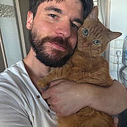 Elvis participe au concours pour gagner de l'argent avec cette photo : man, cat, orange_cat, beard, selfie, portrait, indoors, cuddling, hugging, pet, human, animal, face, eyes, whiskers, fur, orange_fur, white_shirt, home, affection