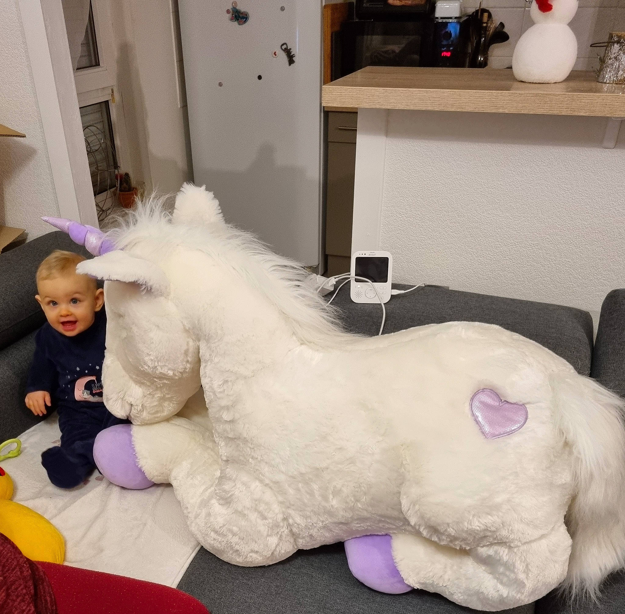 Lucie participe au concours pour gagner de l'argent avec cette photo : fictional_character, flooring, fun, fur, horse, mythical_creature, person, plush, purple, room, stuffed_toy, table, tail, terrestrial_animal, toddler, toy, white