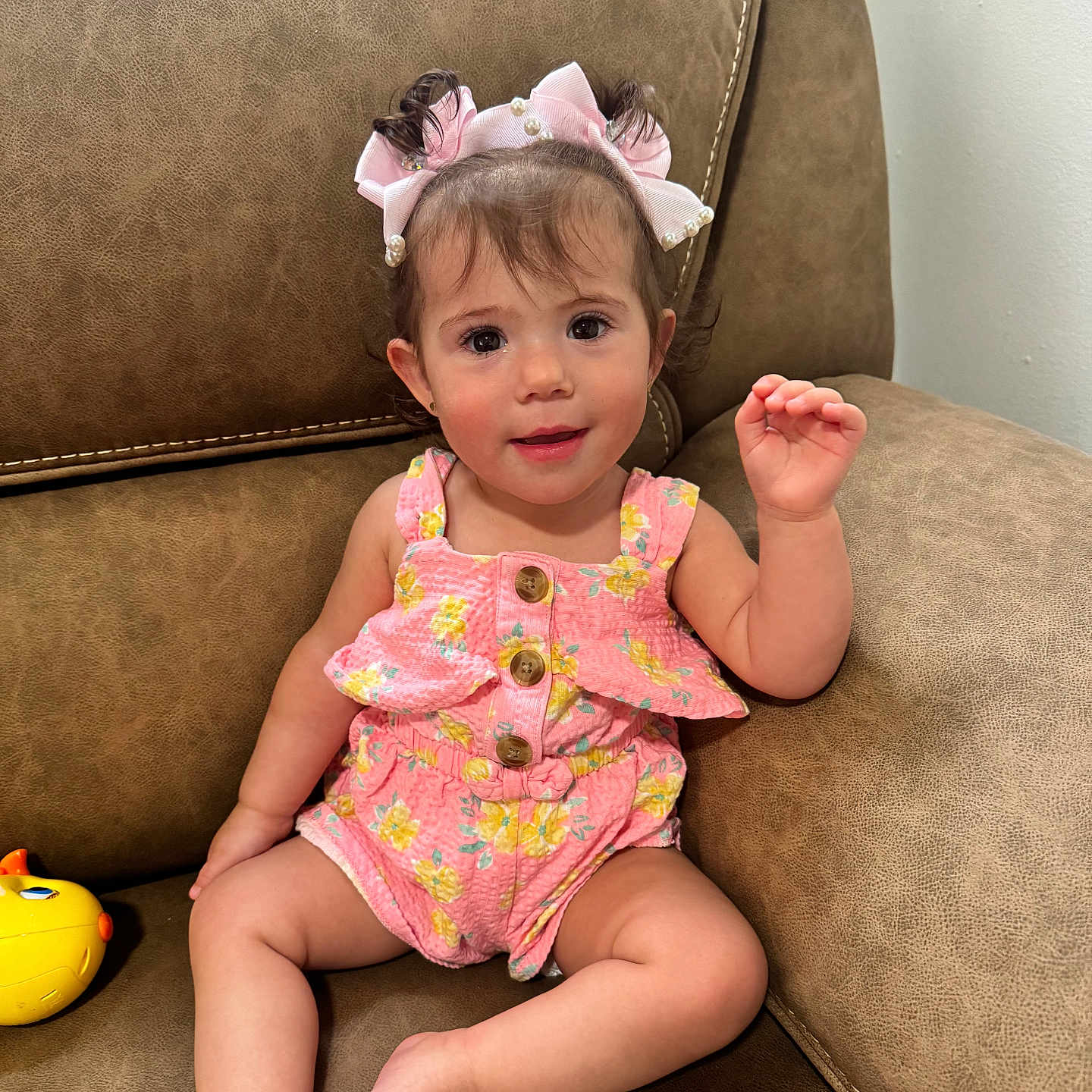 Sofia joined the competition — help win amazing prizes! toddler, child, girl, pink_clothing, pigtails, hair_bows, smile, sitting, couch, brown_leather, toy, indoor, cute, portrait, face, happy, baby, skin, buttoned_romper, young_child