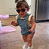 Sofia joined the competition — help win amazing prizes! toddler, child, sunglasses, denim_overalls, indoor, tile_floor, white_shoes, pigtails, smiling, cute, fashion, playful, home, kitchen, door, fridge, young_child, happy, walking, person