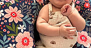 Gracelyn is registered to the contest to win money with this photo: baby, bow, child, colorful, comfort, cushion, cute, floral, flower_pattern, happy, headband, indoor, infant, joyful, person, plush, portrait, romper, sitting, smiling