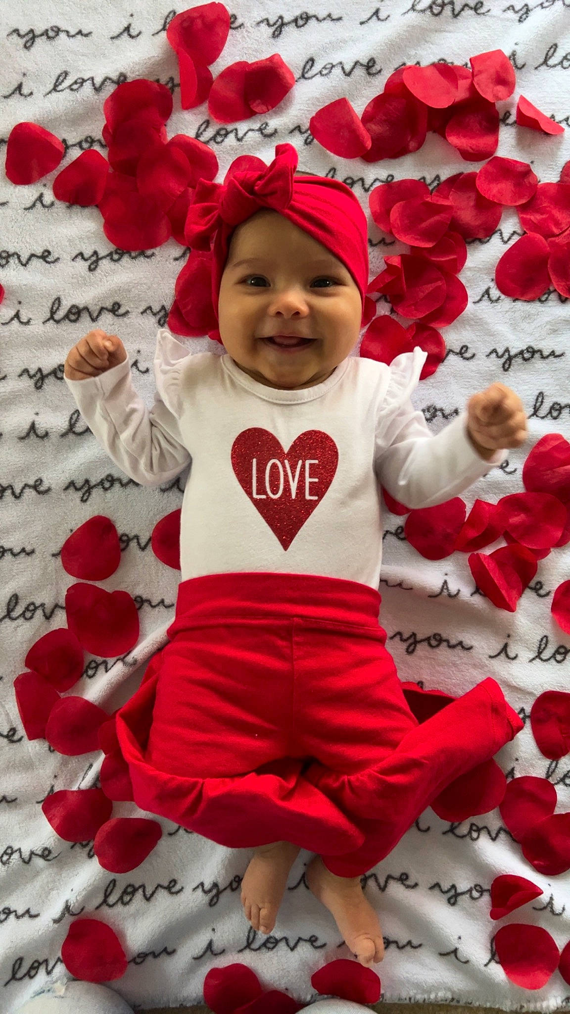 Sophia is registered to the contest to win money with this photo: baby_toddler_clothing, christmas_eve, event, facial_expression, fictional_character, flower, font, happy, hat, headwear, holiday, joy, pattern, person, petal, pink, red, santa_claus, sleeve, smile