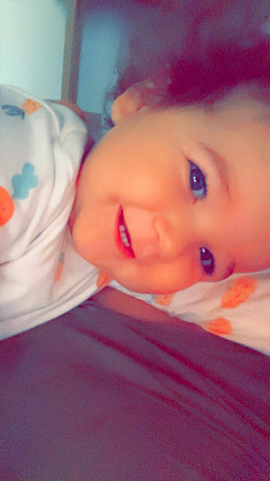 Isaïah participe au concours pour gagner de l'argent avec cette photo : baby, bed, blanket, child, closeup, cozy, cute, face, happy, indoors, infant, lying_down, person, portrait, resting, sleepwear, smile, soft_light, warm_colors, young
