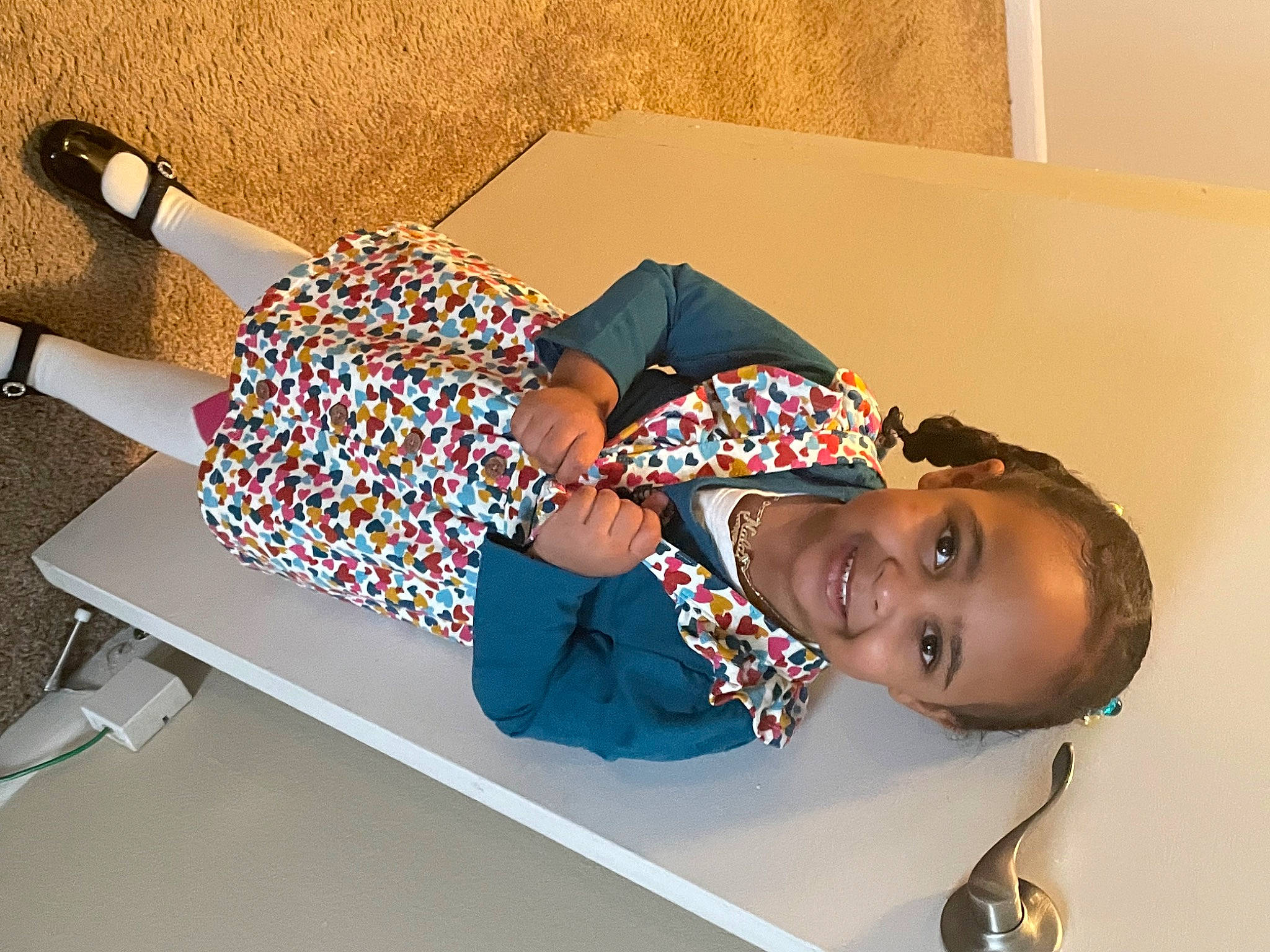 Nala is registered to the contest to win money with this photo: child, comfort, electric_blue, fashion_accessory, flooring, fun, happy, headgear, human_leg, joy, knee, leisure, pattern, person, room, sandal, sleeve, smile, t_shirt, thigh