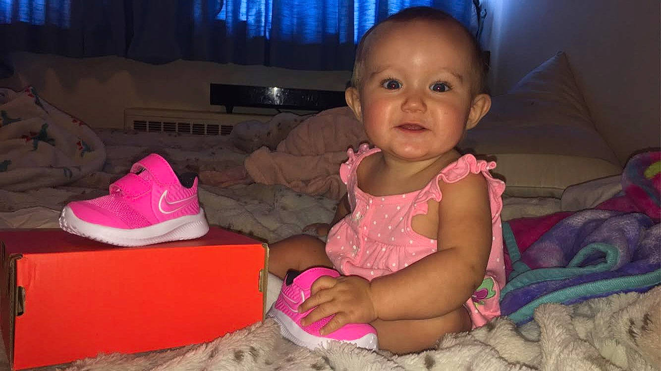 Stella is registered to the contest to win money with this photo: baby, baby_toddler_clothing, cheek, child, comfort, couch, ear, eye, foot, iris, living_room, mouth, nose, person, pink, sitting, skin, television, toddler, tummy_time