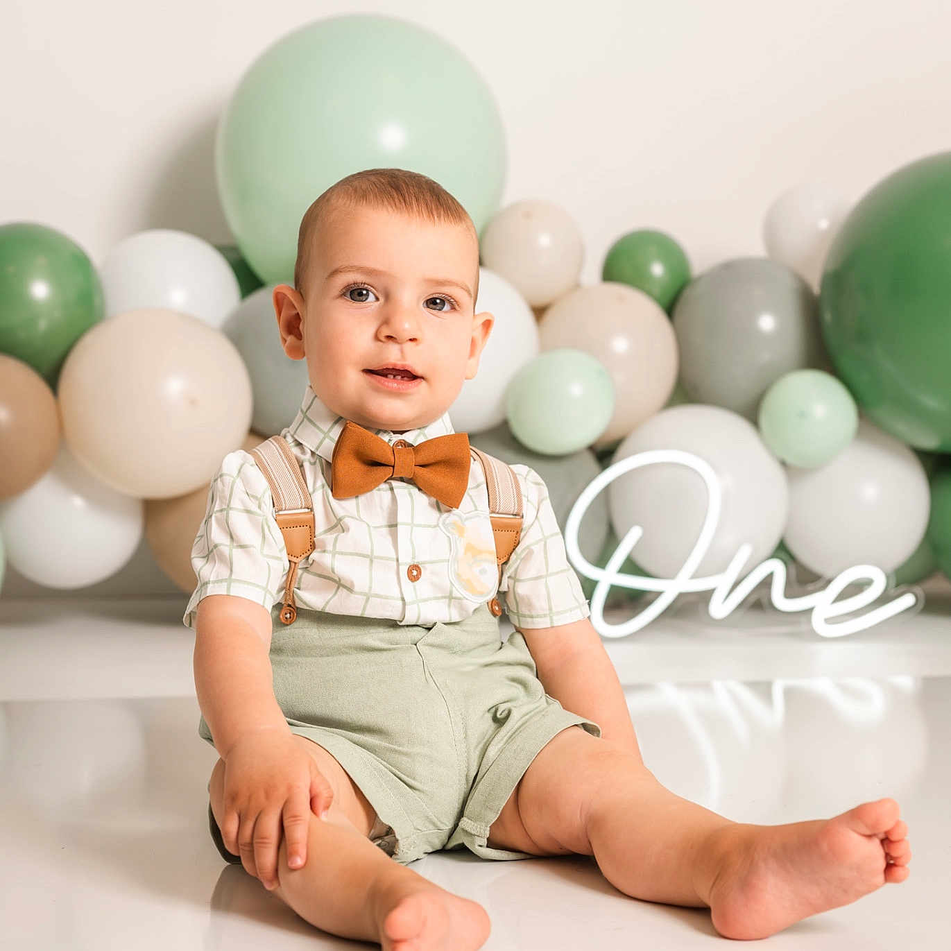Erik joined the competition — help win amazing prizes! child, toddler, boy, portrait, sitting, smiling, bow_tie, suspenders, shorts, balloons, pastel, birthday, party, studio, indoor, white_background, floor, reflection, celebration, photography