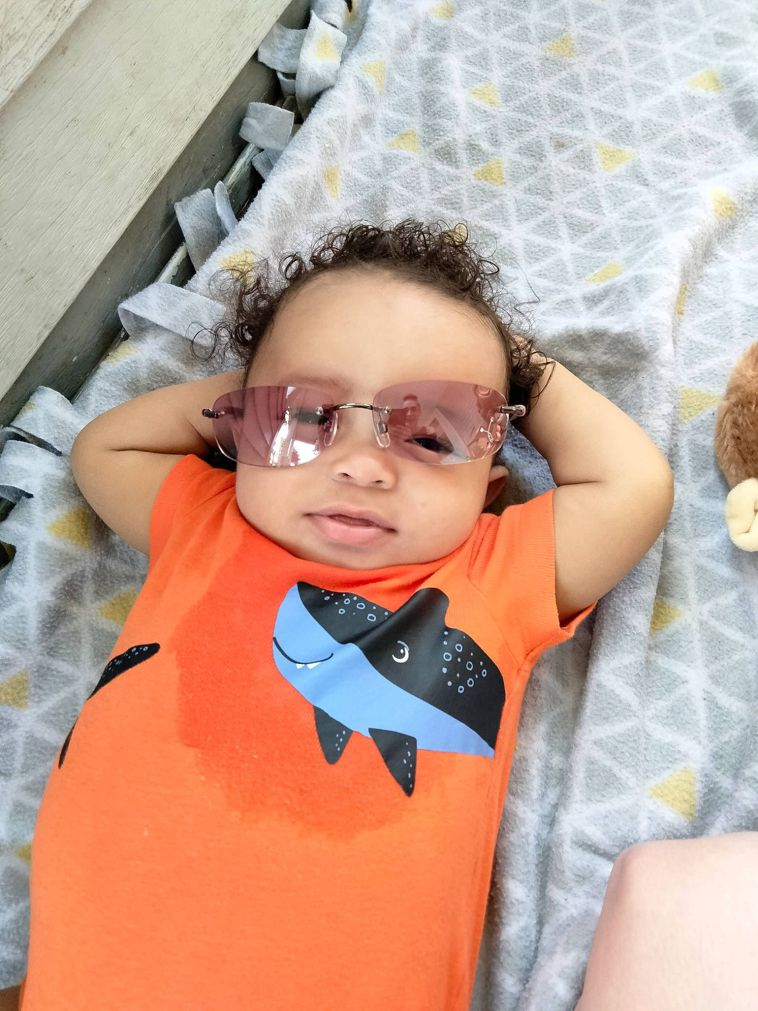 Jericho is registered to the contest to win money with this photo: baby_toddler_clothing, chin, comfort, eye, eyewear, fun, glasses, hair, happy, head, leisure, orange, pattern, person, sitting, skin, sleeve, sunglasses, textile, toddler
