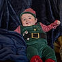 Xavier-James joined the competition — help win amazing prizes! baby, child, cozy, cute, elf_outfit, festive, holiday_costume, indoor, infant, navy_blanket, person, plush_blanket, portrait, red_socks, seated, smiling, soft_texture, striped_hat, warm_clothing, young_child