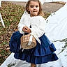 child, girl, portrait, outdoor, smiling, dress, white_coat, blue_dress, silver_boots, wicker_basket, headband, pearl_accessories, fashion, formalwear, standing, garden, grass, fallen_leaves, white_fabric, full_body