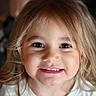 child, girl, toddler, portrait, close_up, smiling, happy, face, eyes, teeth, blonde_hair, long_hair, brown_eyes, white_shirt, indoor, soft_lighting, headshot, photography, cute, person